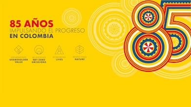 La imagen representa la identidad visual creada para celebrar el 85 aniversario de la presencia de Shell en Colombia. El texto en el fondo amarillo dice: “85 años impulsando el progreso en Colombia”, seguido por los cuatro iconos que representan los pilares de la estrategia de Shell “Impulsando el Progreso”: En la derecha, una representación artística del número 85 connotando los tradicionales sombreros vueltiaos de Colombia en rojo, blanco, amarillo y azul.