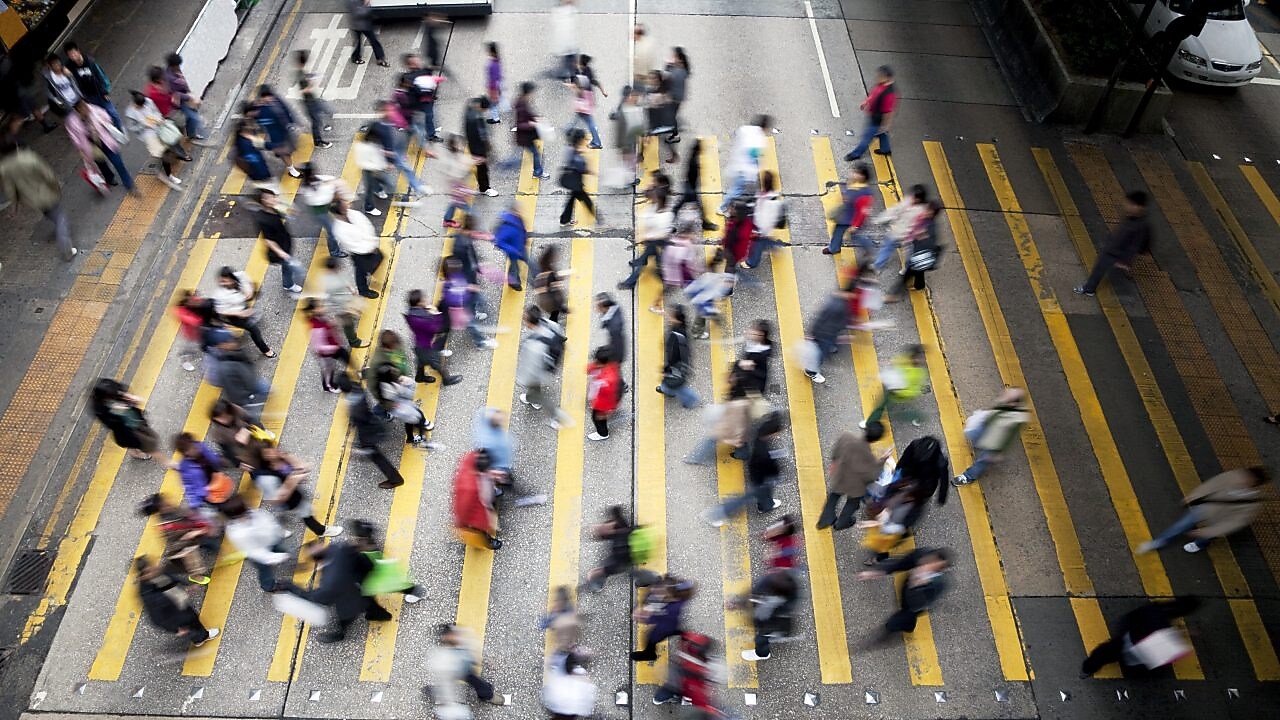 Personas cruzando una calle llena de gente en Hong&nbsp;Kong