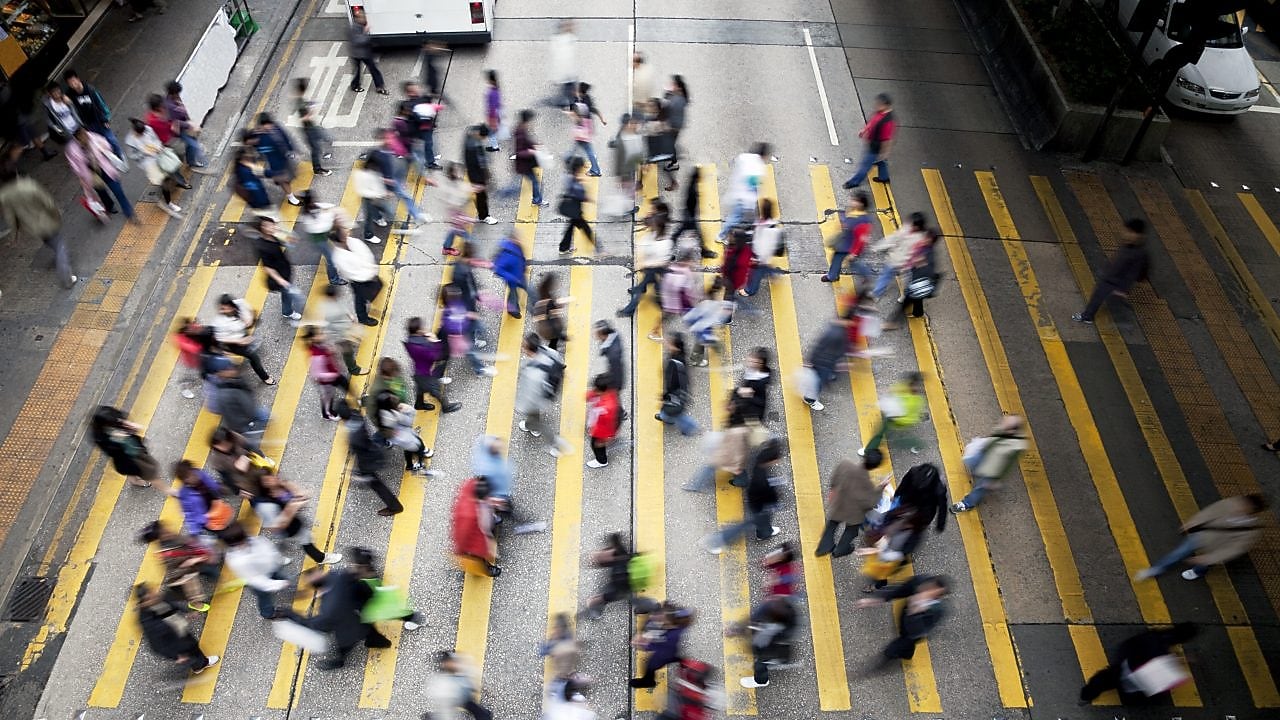Personas cruzando una calle llena de gente en Hong Kong