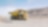 yellow dumper truck driving through gravel