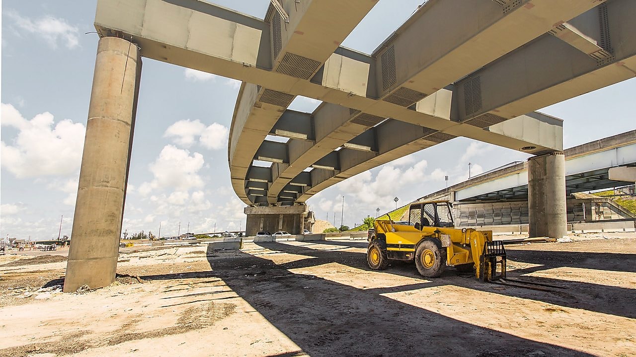 a digger truck under a flyover which is under construction