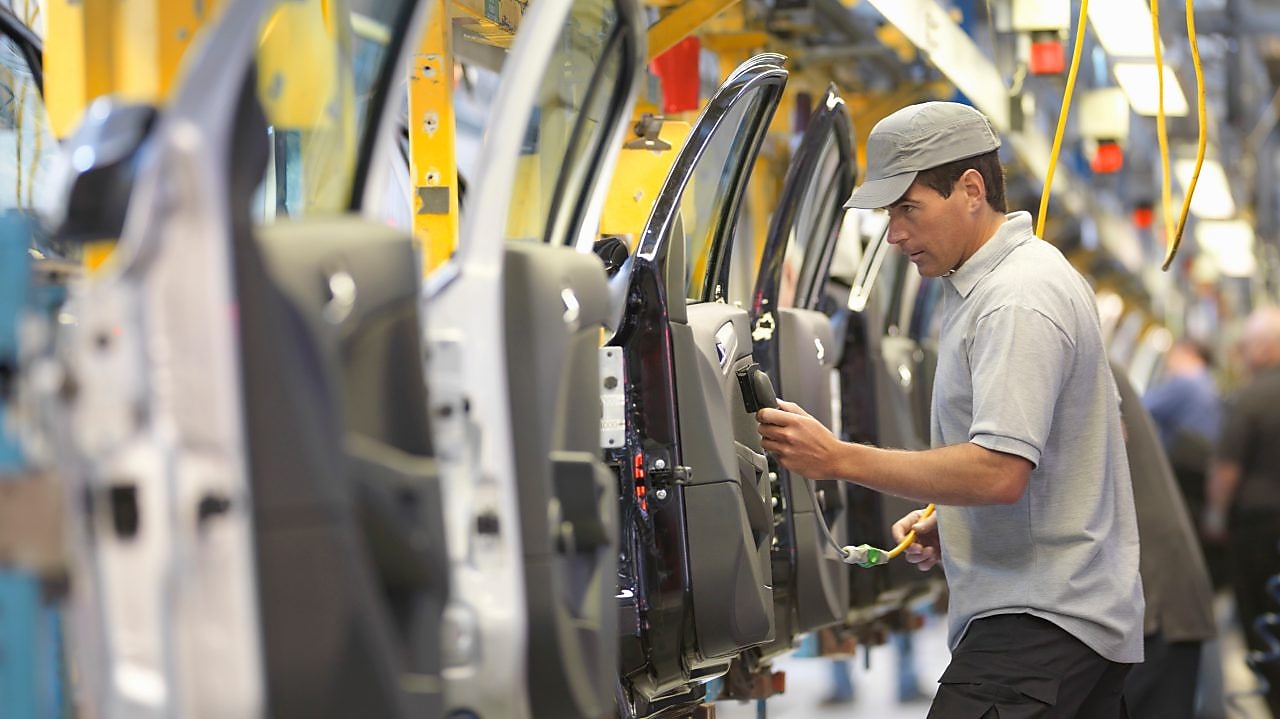 man holding wire looking at machine