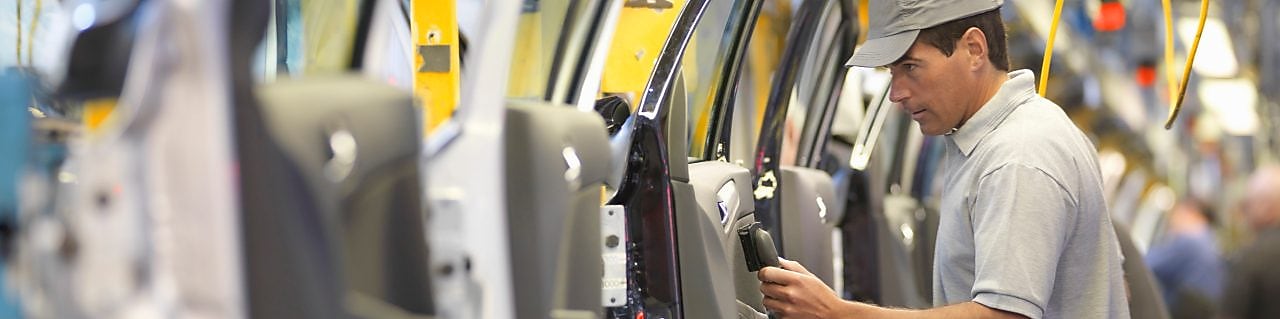 man holding wire looking at machine