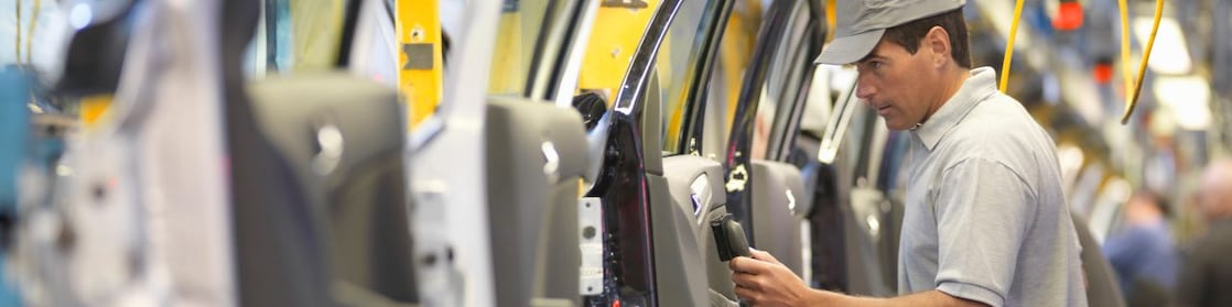 man holding wire looking at machine