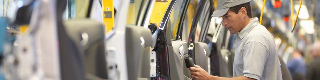 man holding wire looking at machine