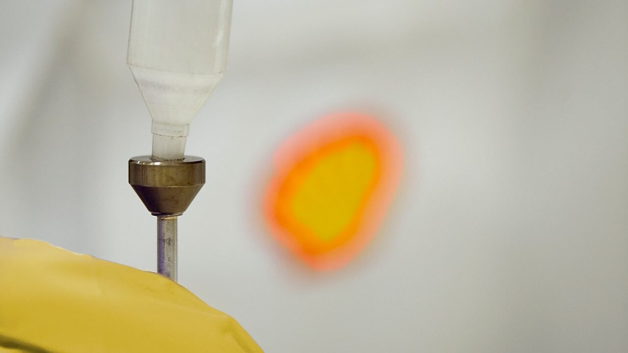 Un científico de Shell vierte líquido en un embudo de plástico en un laboratorio