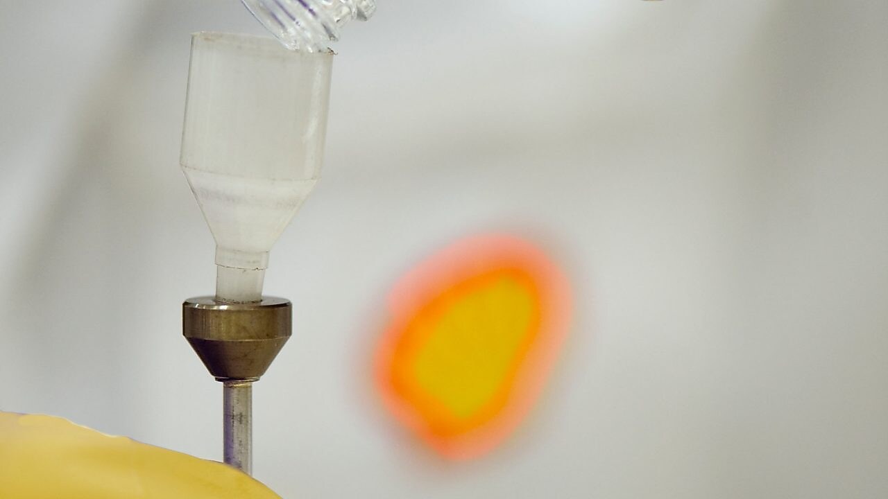 Un científico de Shell vierte líquido en un embudo de plástico en un laboratorio