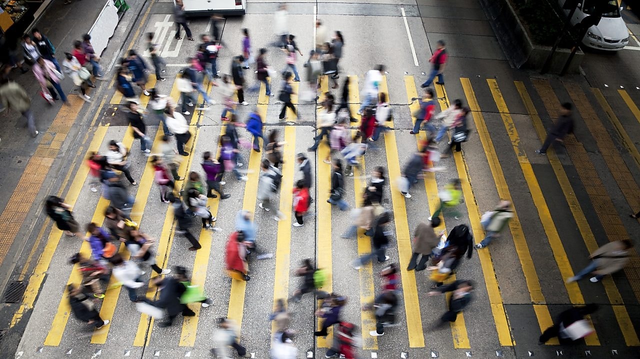 Personas cruzando una calle llena de gente en Hong&nbsp;Kong