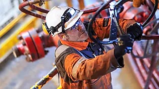 Hombre trabajando en una plataforma con el uniforme de seguridad completo