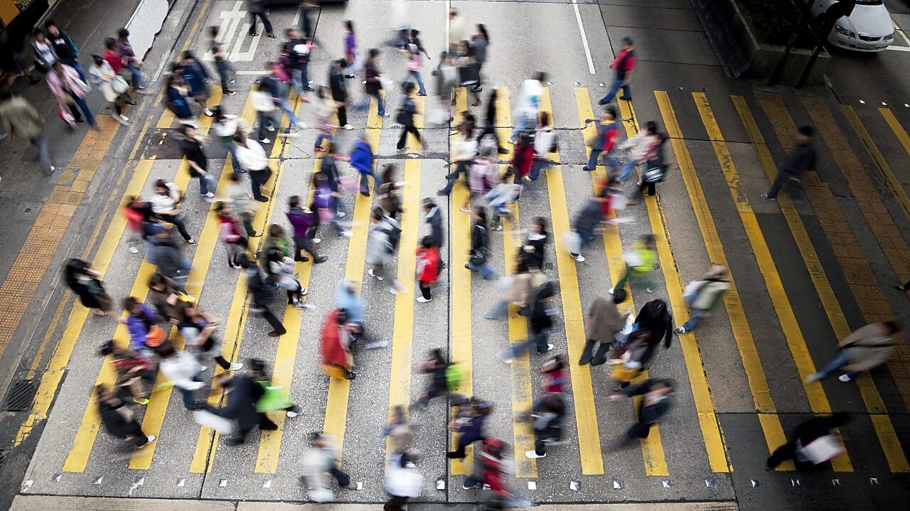 Personas cruzando una calle llena de gente en Hong Kong