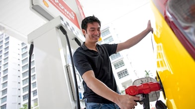Hombre repostando su coche en una gasolinera
