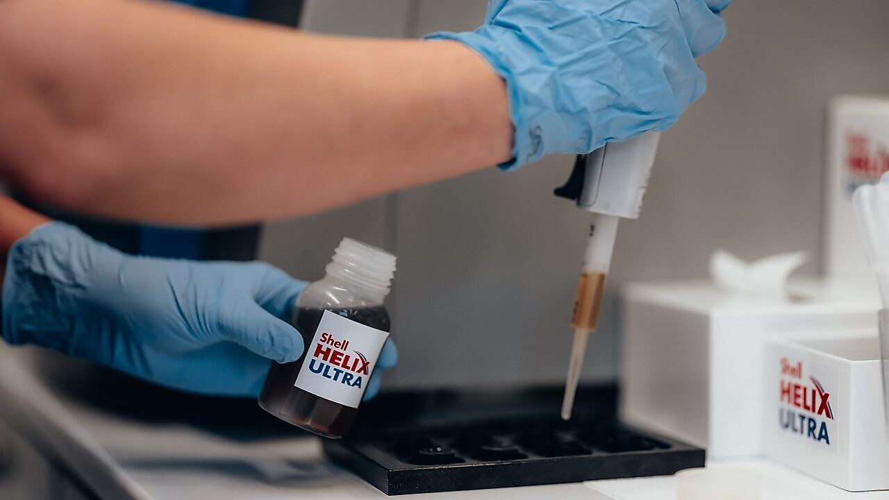 Engineer holding sample bottle with gloved hands